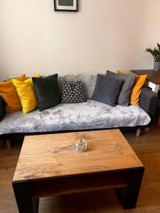 a living room with a couch with colorful pillows at Apartament Na Rynku in Bytom +13 photos