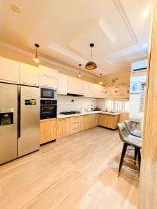 a kitchen with stainless steel appliances and wooden cabinets at Casa Midelle in Alagbado