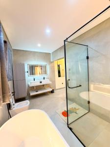 a bathroom with a tub and a toilet and a sink at Casa Midelle in Alagbado +16 photos