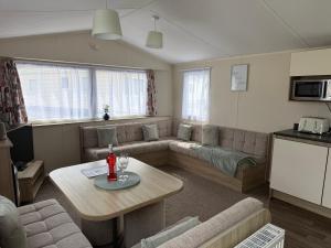 a living room with a couch and a table at Challaborough caravan in Burgh Island