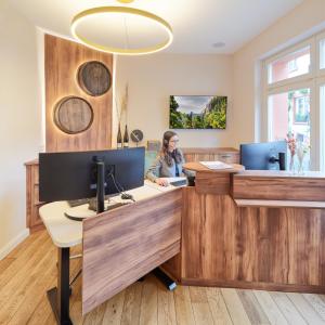 a woman sitting at a desk in an office at Hotel Zeltinger-Hof - Gasthaus des Rieslings in Zeltingen-Rachtig +37 photos