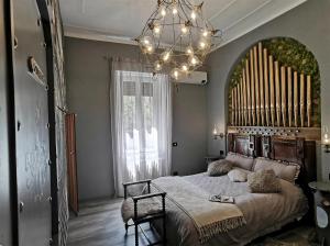 a bedroom with a large bed and a chandelier at The Kraken Inn - Steampunk Boutique B&B in Bergamo in Bergamo