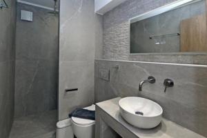 a bathroom with a sink and a toilet and a mirror at Agios Nikolaos Villas in Agios Nikolaos