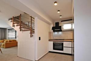 a kitchen with a staircase and a living room at Agios Nikolaos Villas in Agios Nikolaos