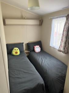 two twin beds in a small room with at Challaborough caravan in Burgh Island +14 photos