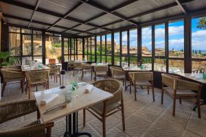 a restaurant with tables and chairs and large windows at Palazzo Saloni in Montalcino