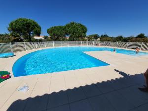 a large swimming pool with blue water at Villa Belle Ile in Saint-Pierre-dʼOléron