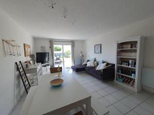a living room with a couch and a table at Villa Belle Ile in Saint-Pierre-dʼOléron
