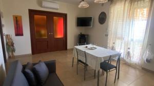 a dining room with a white table and chairs at Sole nascente in Furci Siculo