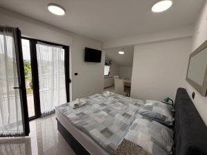 a bedroom with a bed and a large window at Rooms Vesna in Salopek-Selo