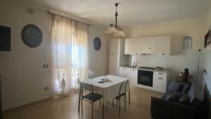 a kitchen and dining room with a table and chairs at Sole nascente in Furci Siculo