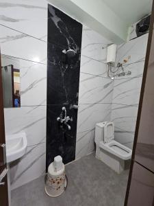 a bathroom with a toilet and a sink at Arya Palace in Phulabāni
