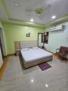a bedroom with a bed and a chair in it at Arya Palace in Phulabāni +12 photos