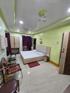 a bedroom with a bed and chairs in a room at Arya Palace in Phulabāni