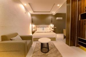 a hotel room with a bed and a couch and a table at Garden Ridge in Abuja