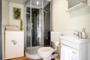 a bathroom with a shower and a toilet and a sink at Herbal Garden Resort Plahtica in Jurklošter