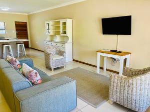 a living room with a couch and a tv at Travalia Guest Farm in Nelspoort