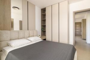 a bedroom with a large bed with white walls at D & D Apartments in Kassandra