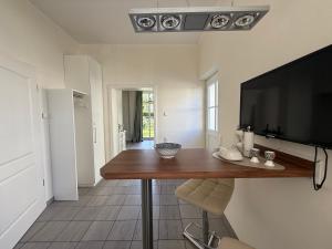 a living room with a table and a flat screen tv at Schonekind Appartement Soest in Soest