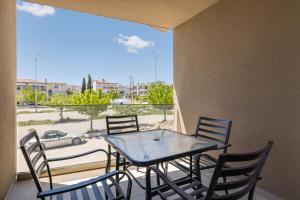 a table and chairs on a balcony with a view of a car at D & D Apartments in Kassandra