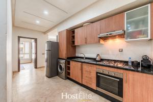 a kitchen with wooden cabinets and a stainless steel refrigerator at Appartement Central Park - Clim - 10 min plage in Mohammedia