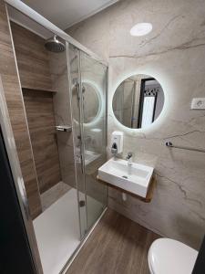 a bathroom with a shower and a sink and a mirror at Rooms Vesna in Salopek-Selo +28 photos