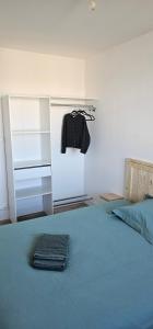 a bedroom with a bed with a shirt hanging on the wall at Appartement T4 proche gare in Guingamp