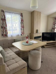 a living room with a table and a couch at Challaborough caravan in Burgh Island