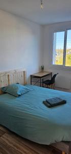 a bedroom with a bed and a desk and a window at Appartement T4 proche gare in Guingamp