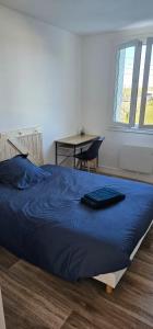 a bedroom with a bed with a blue blanket on it at Appartement T4 proche gare in Guingamp