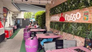 a restaurant with purple tables and chairs on a brick wall at Castello Rosso Apartman in Pilisvörösvár