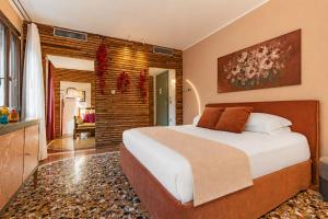 a bedroom with a large bed and a brick wall at Cinqueteste Luxury Home in Venice