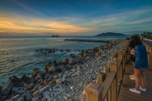 a woman standing on a pier looking at the water at Greek Wonderland B&B in Hualien City