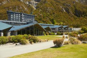 a large building with a mountain in the background at The Hermitage Hotel Mt Cook in Mount Cook Village