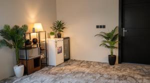 a room with two potted plants and a refrigerator at شاليه السيل الكبير in As Sayl al Kabīr