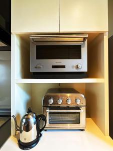 a kitchen with a microwave and a tea kettle at SENJA Dewata in Mitoyo