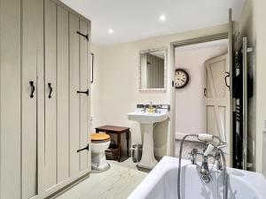 a bathroom with a sink and a toilet and a tub at Whitley Farm Molland in Molland +40 photos