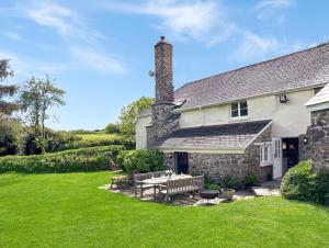 a stone house with a picnic table in the yard at Whitley Farm Molland in Molland