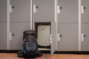 a backpack and a suitcase sitting in front of doors at Foresteria Valdese di Firenze in Florence