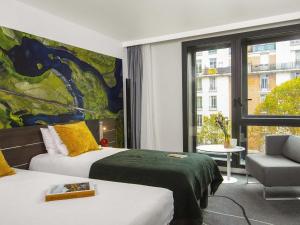 a hotel room with two beds and a window at Novotel Paris Porte Versailles in Paris +176 photos