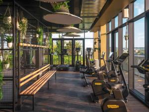 a gym with a row of treadmills and ellipticals at Novotel Paris Porte Versailles in Paris