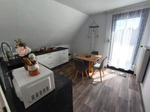 a kitchen and dining room with a table and a microwave at FeWo Rina in Pottenstein