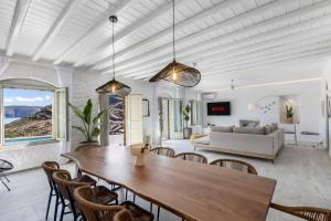 a living room with a table and chairs and a couch at Villa Evita Panormos private pool & jacouzzi in Mykonos