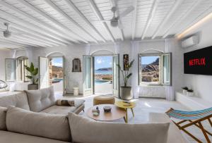 a living room with a couch and a table at Villa Evita Panormos private pool & jacouzzi in Mykonos