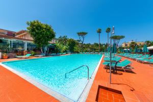 a large swimming pool with chairs and umbrellas at Grand Hotel Delle Terme Re Ferdinando in Ischia Town