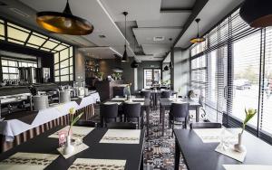 a restaurant with tables and chairs in a room at Apartament Atrium Sarbinowo in Sarbinowo