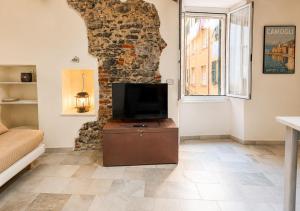 a living room with a tv and a stone wall at Iris 3: Un Fiore a Camogli in Camogli +1 photo