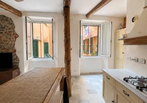 a kitchen with a stove and two windows and a counter at Iris 3: Un Fiore a Camogli in Camogli
