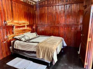 a bedroom with a bed in a wooden wall at Xitlaly cabins in La Montaña