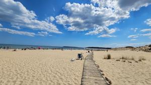 a wooden boardwalk on a beach with a crowd of people at Hotel Longosa - All Inclusive Family Hotel near the beach in the peaceful southern part of Sunny Beach in Sunny Beach